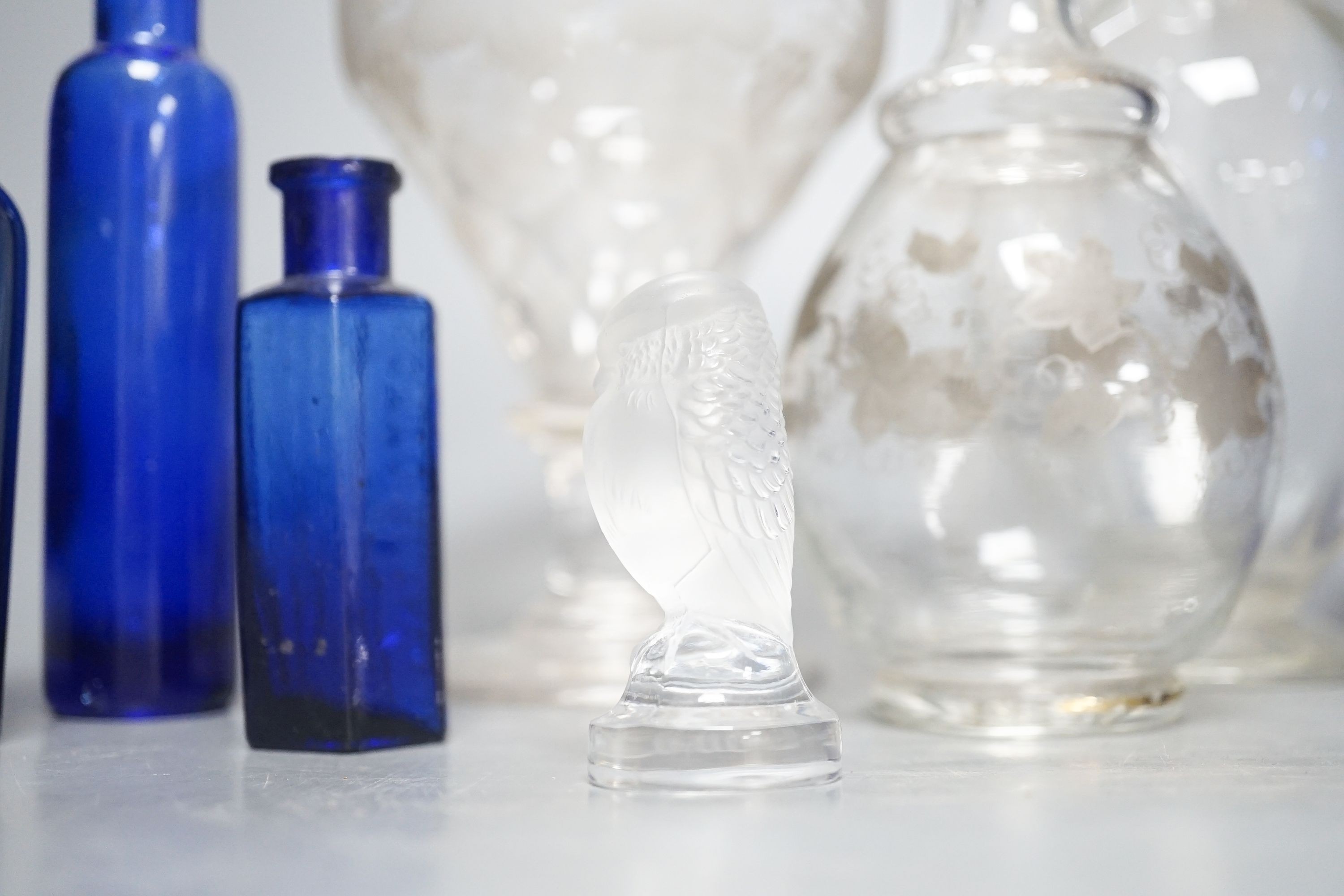 A Lalique frosted glass bird, etched Wedgwood ‘plant a tree ‘73’ glass, other etched glasses, decanters and blue glass pharmacy bottles